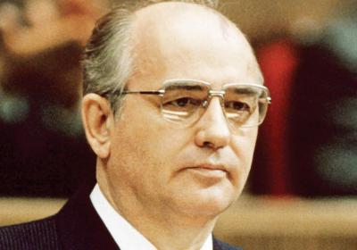 Mikhail Gorbachev seated behind microphones