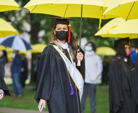 学生们打着黄伞走向毕业典礼