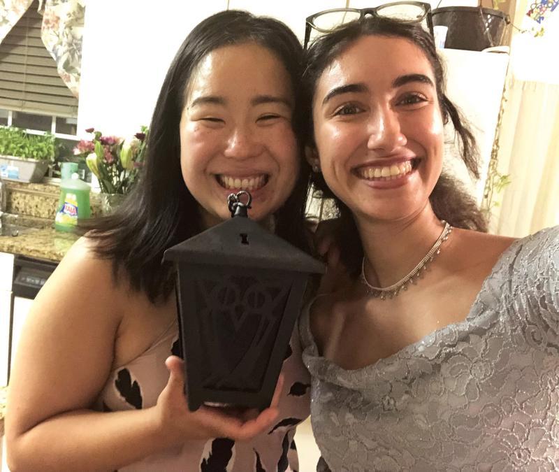 Dounya Ramadan and Lizzy Lee standing together, holding a lantern
